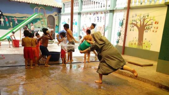 Religiosas y voluntarios comparten la alegría del juego con agua en hogar de niños